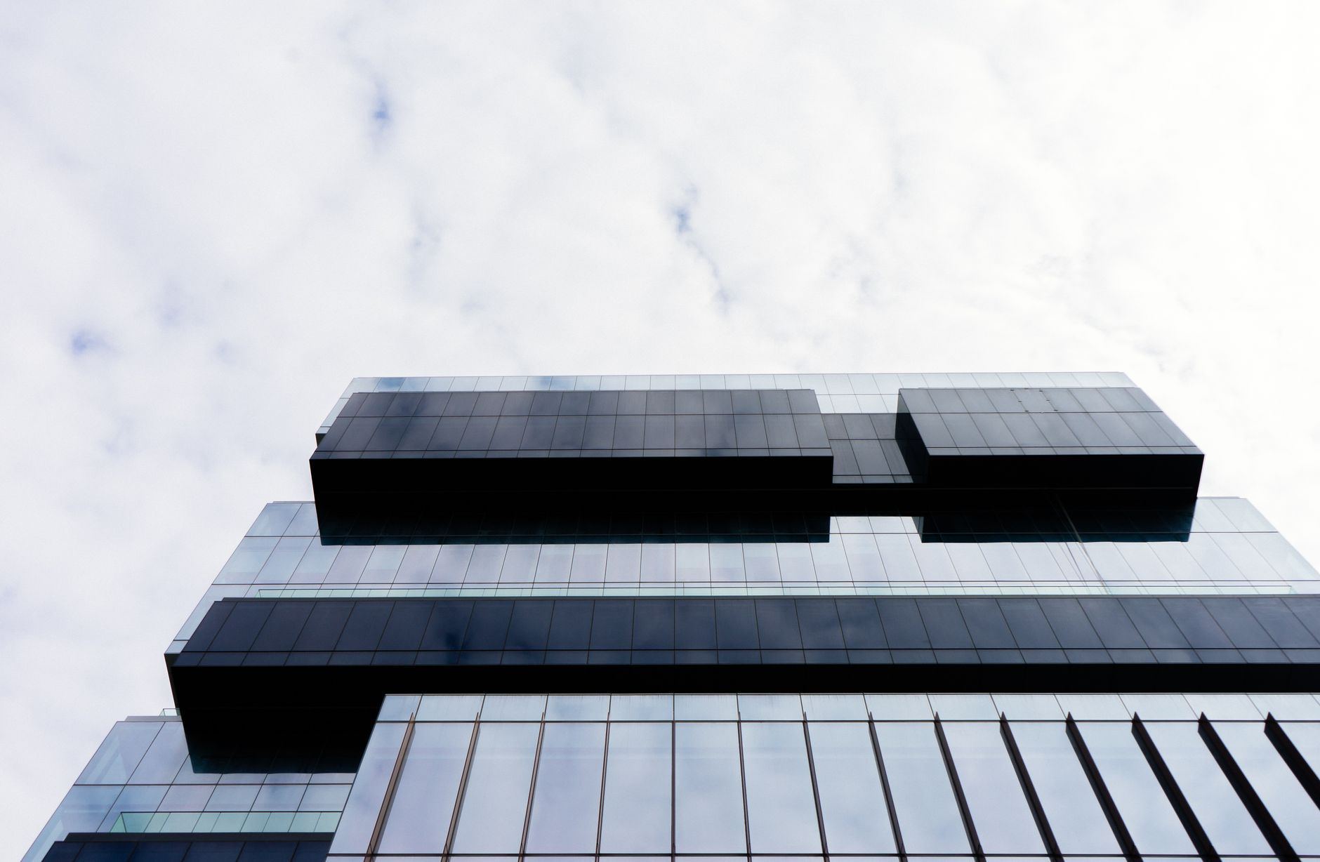 Edificio contemporáneo de fachada de vidrio visto desde abajo