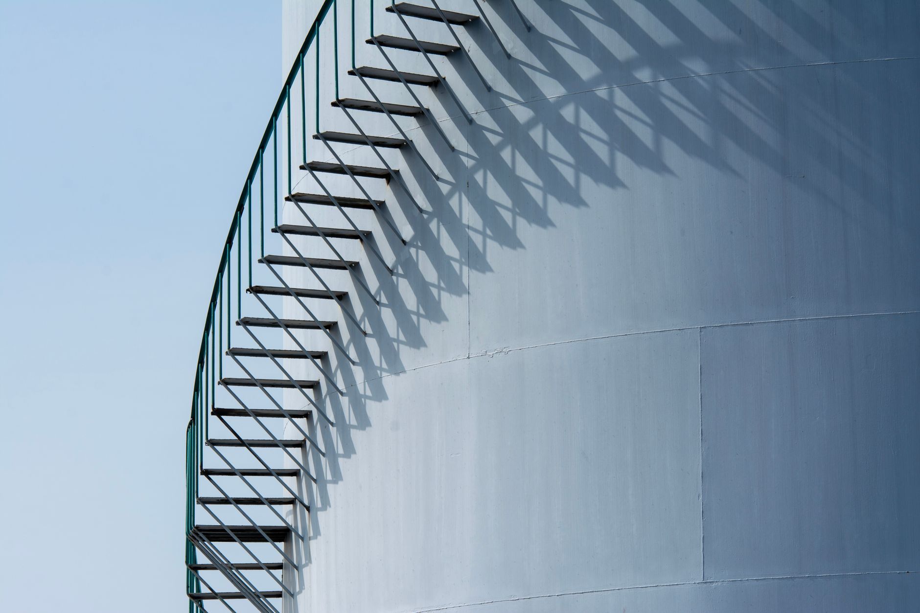 Escalera metálica y sus sombras sobre una pared azul